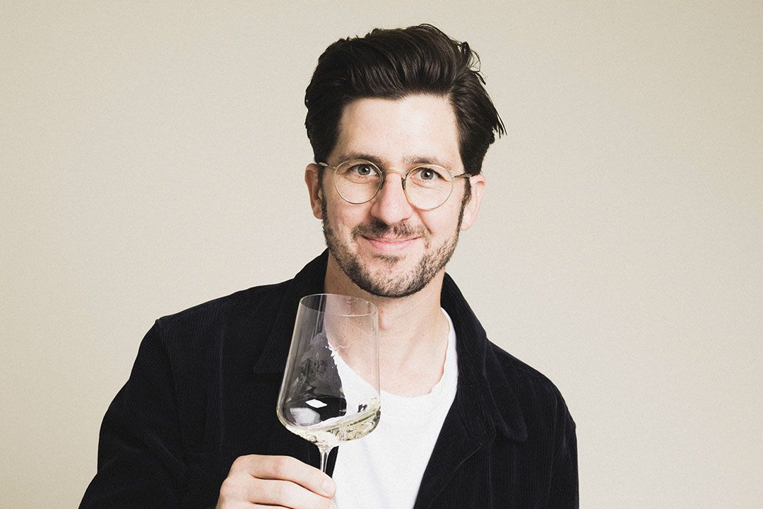 Sommelier Chris hält ein Weißweinglas in der Hand