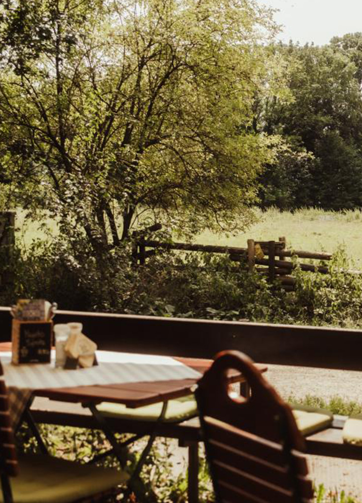 Sitzplatz im Biergarten der Emmeramsmühle mit Blick ins Grüne